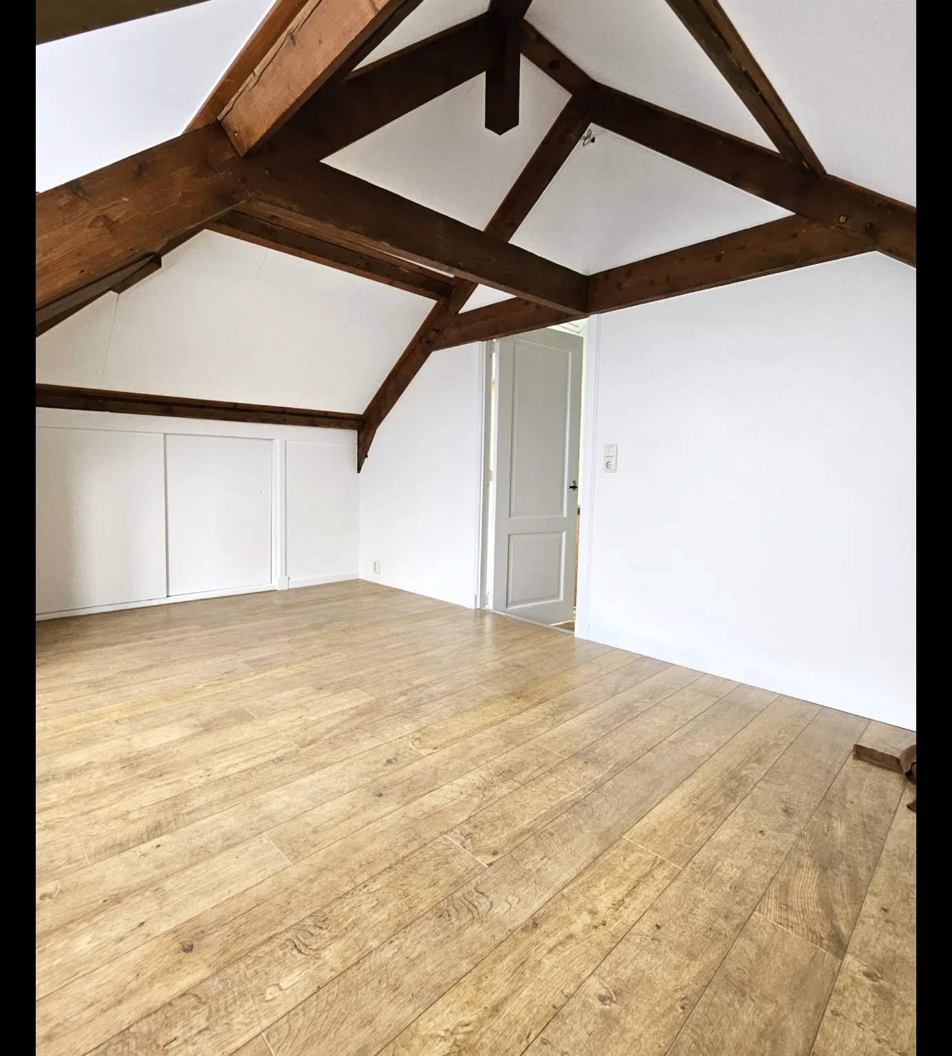 Zolderinterieur — strak wit schilderwerk met houten balken